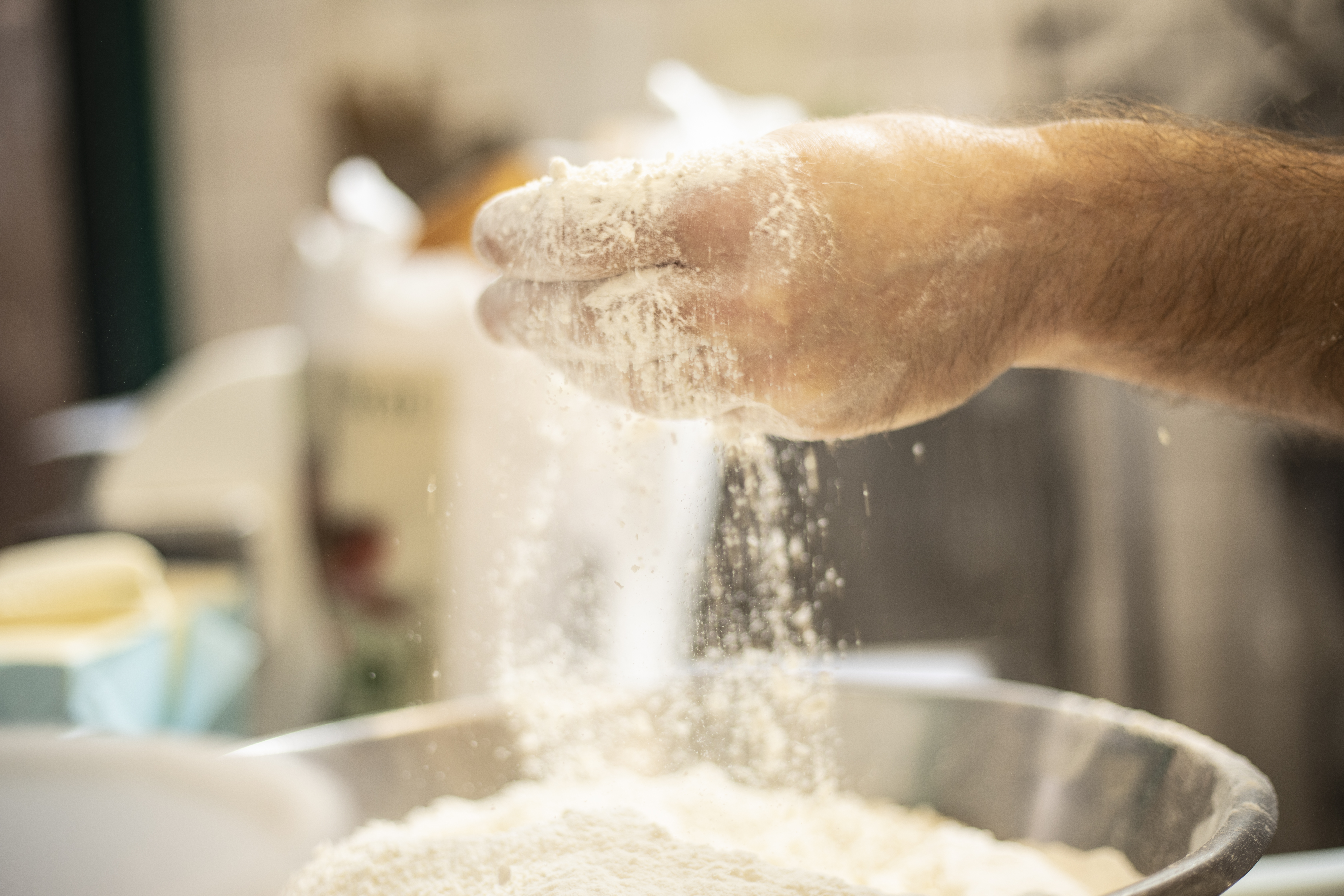 Hånd tilsætter mel