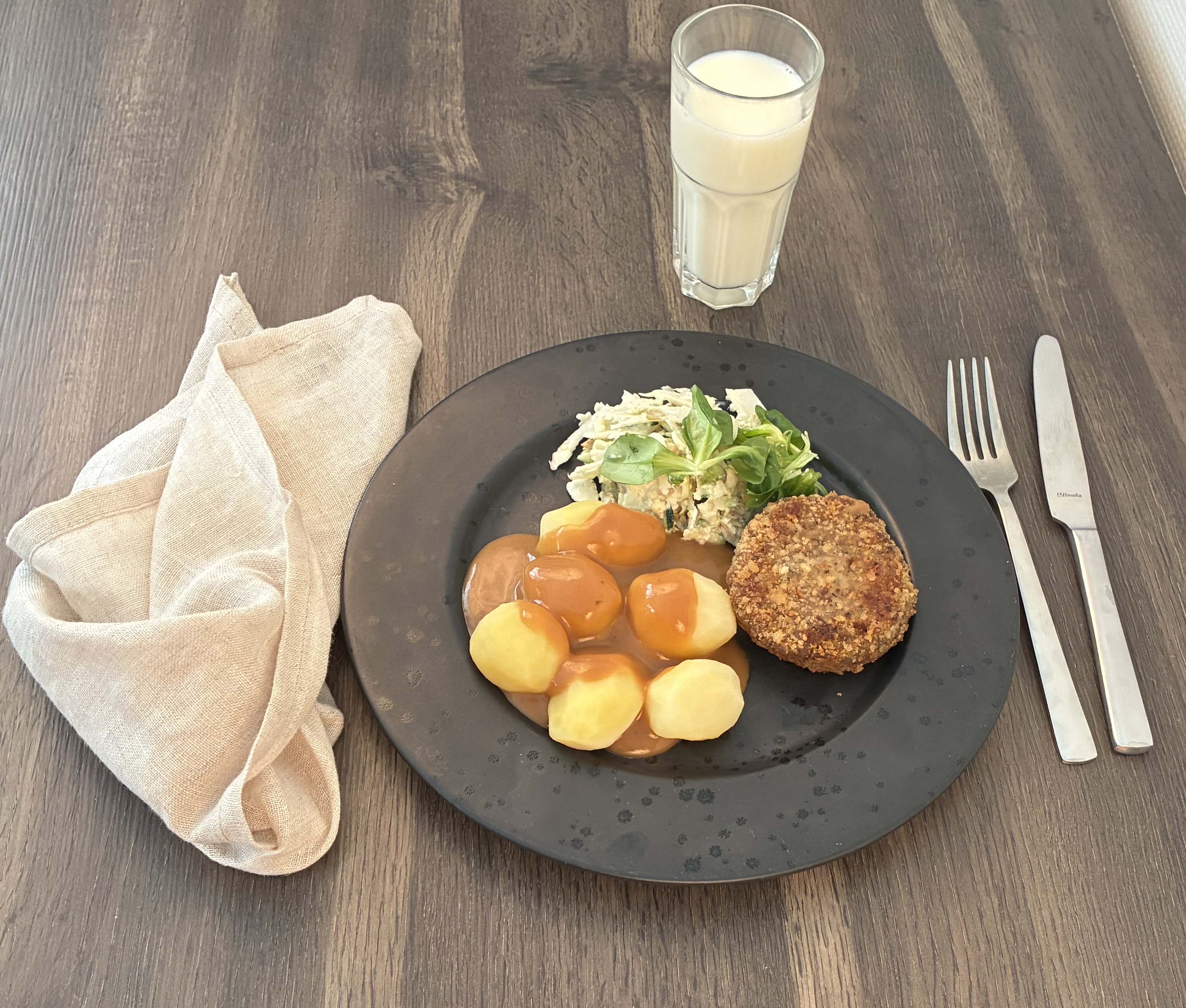 Anretning med karbonade, salat og kartofler med sovs