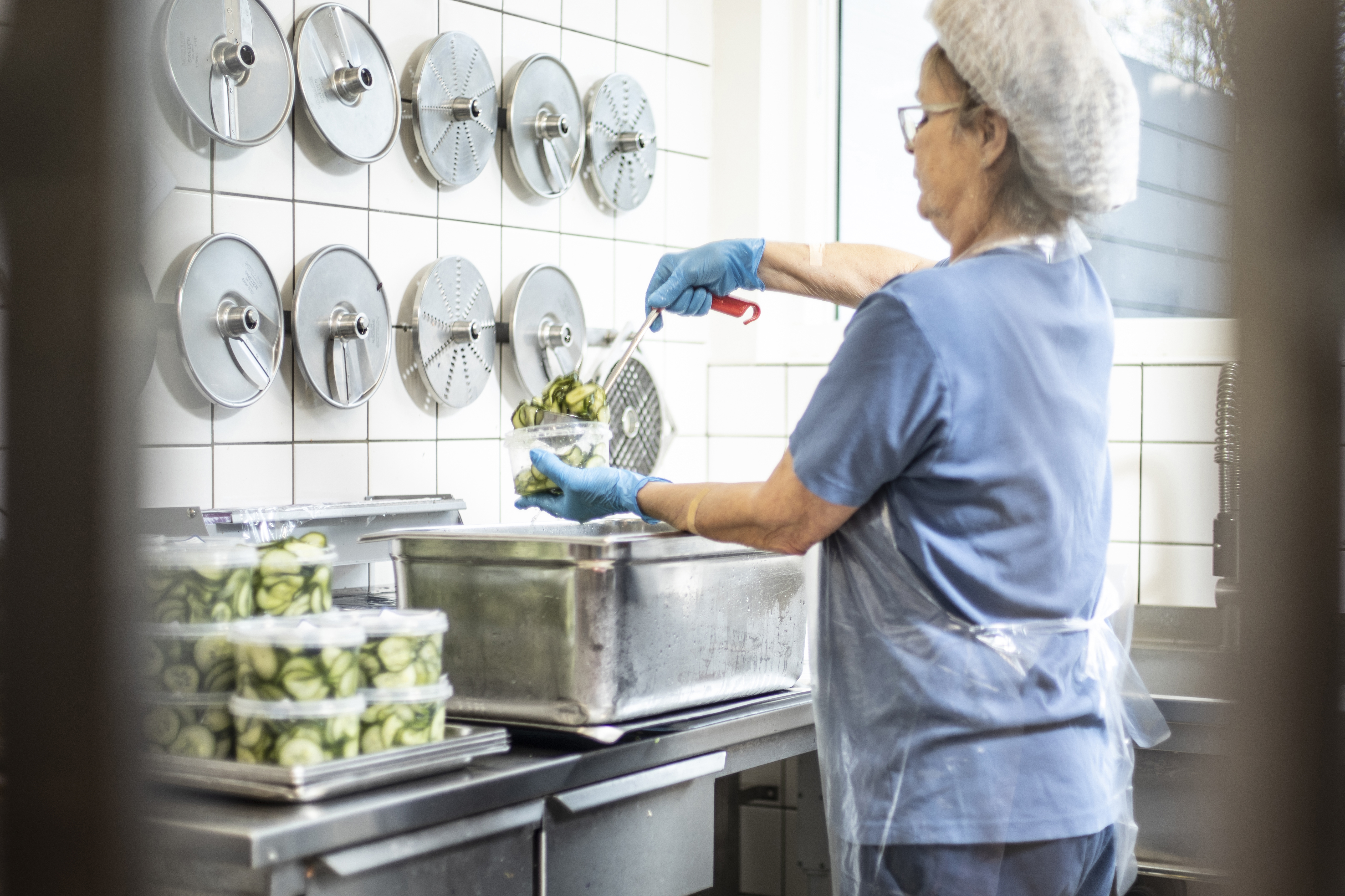 Medarbejder pakker hjemmelavet agurkesalat