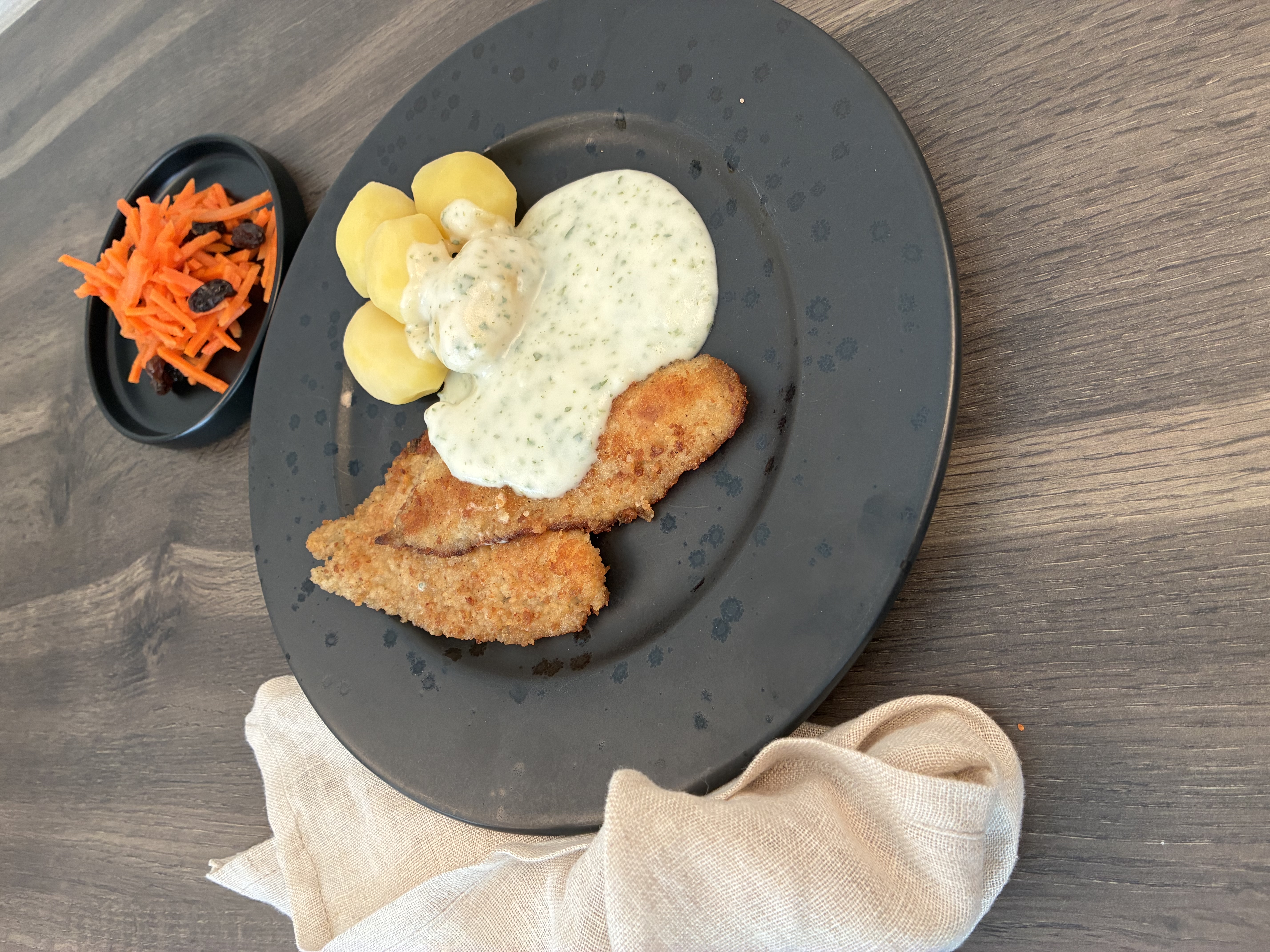 Tallerken med paneret kød, sovs, kartofler og salat