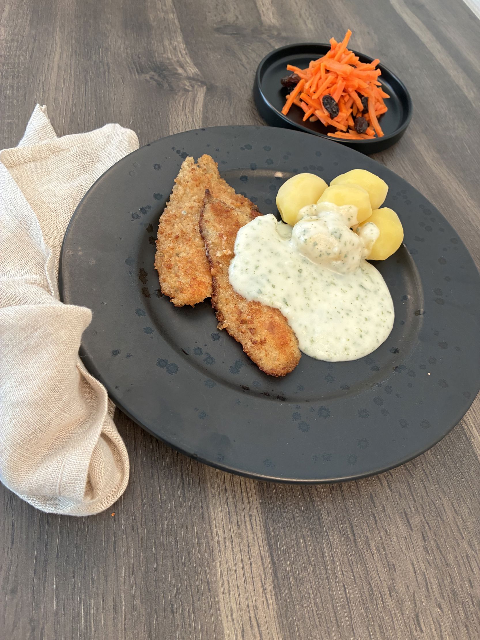 Tallerken med paneret kød, sovs, kartofler og salat