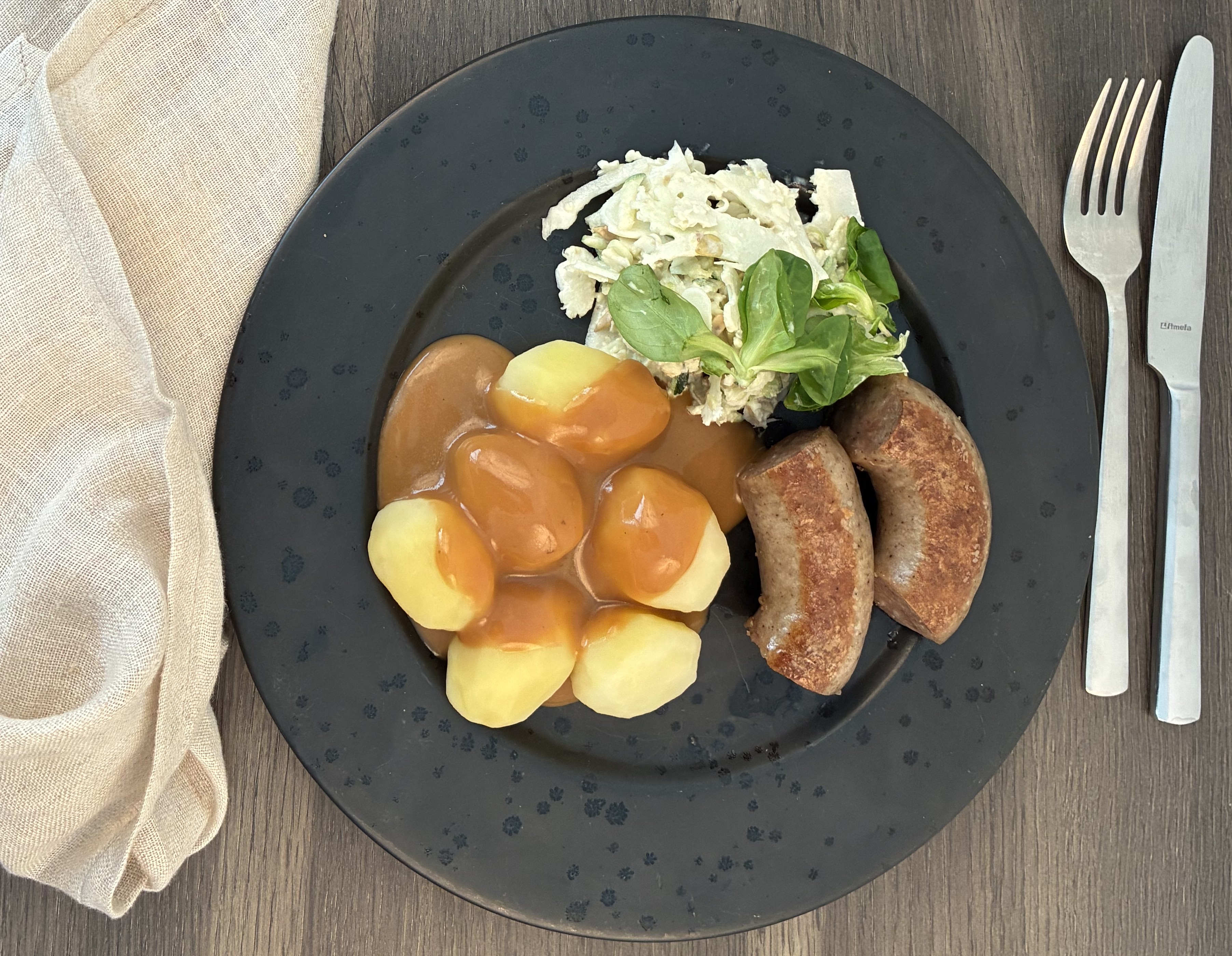 Anretning med stegt medister, kartofler med sovs og salat
